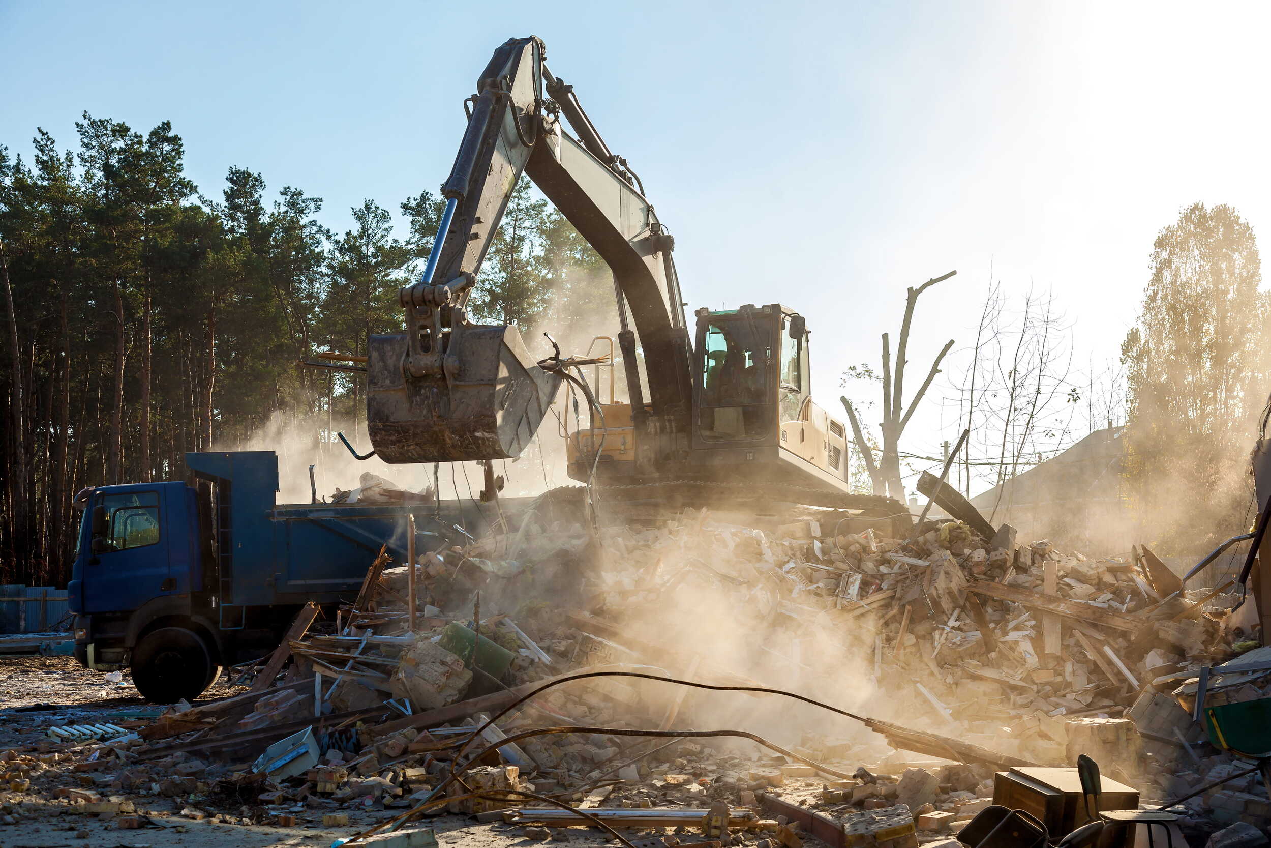 excavator-loads-remains-destroyed-building-car